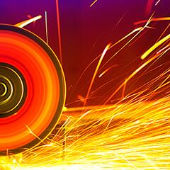A metal circular saw going through sheet metal with sparks flying