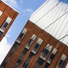 A Brick building reflected in the windows of a commercial building