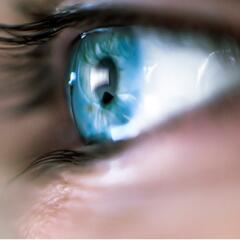 Close up picture of a person's bright blue eye with long eyelashes