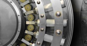A close-up of a polished steel bank vault locking mechanism