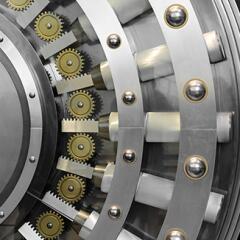 A close-up of a polished steel bank vault locking mechanism