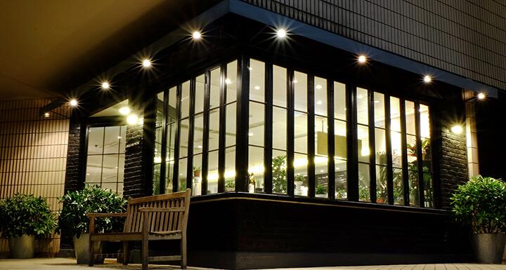 Sidewalk view of a brightly lit closely held plant business