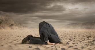 businessman hiding head in the sand