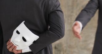 Businessman holding white mask in his hand dishonest cheating agreement