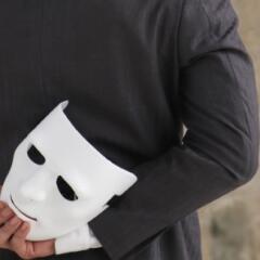 businessman holding white mask in his hand dishonest