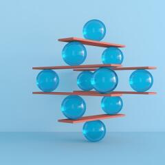 Abstract image of balls balancing on wooden slats in increasing complexity