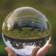 crystal ball with inverted image of green natural landscape