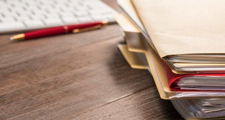 a stack of manila legal file folders on a desktop