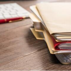 a stack of manila legal file folders on a desktop