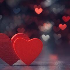 two red hearts against holiday defocused lights