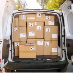 Back of van with both doors open and full of brown box parcels