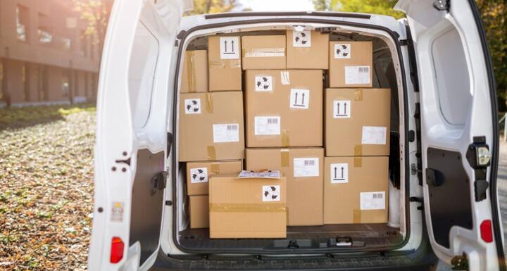 Back of van with both doors open and full of brown box parcels