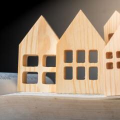 wooden house-shaped toys are arranged on top of an open book