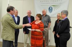 Bob Logan, president of the Wayne County Community Foundation, presents a check from NCCF’s Disaster Relief Fund to Barbara Stiles of Wayne County’s Long Term Recovery Group.