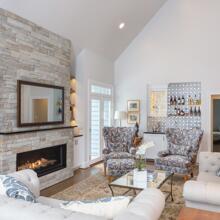 Governors Club - pale gray living room with stone fireplace & wet bar