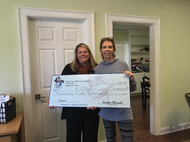 Pirates Cove Billfish Tournament Director Heather Maxwell (right) poses for a check presentation photo with Natalie Jenkins Peel, NCCF regional director, while establishing the endowment.