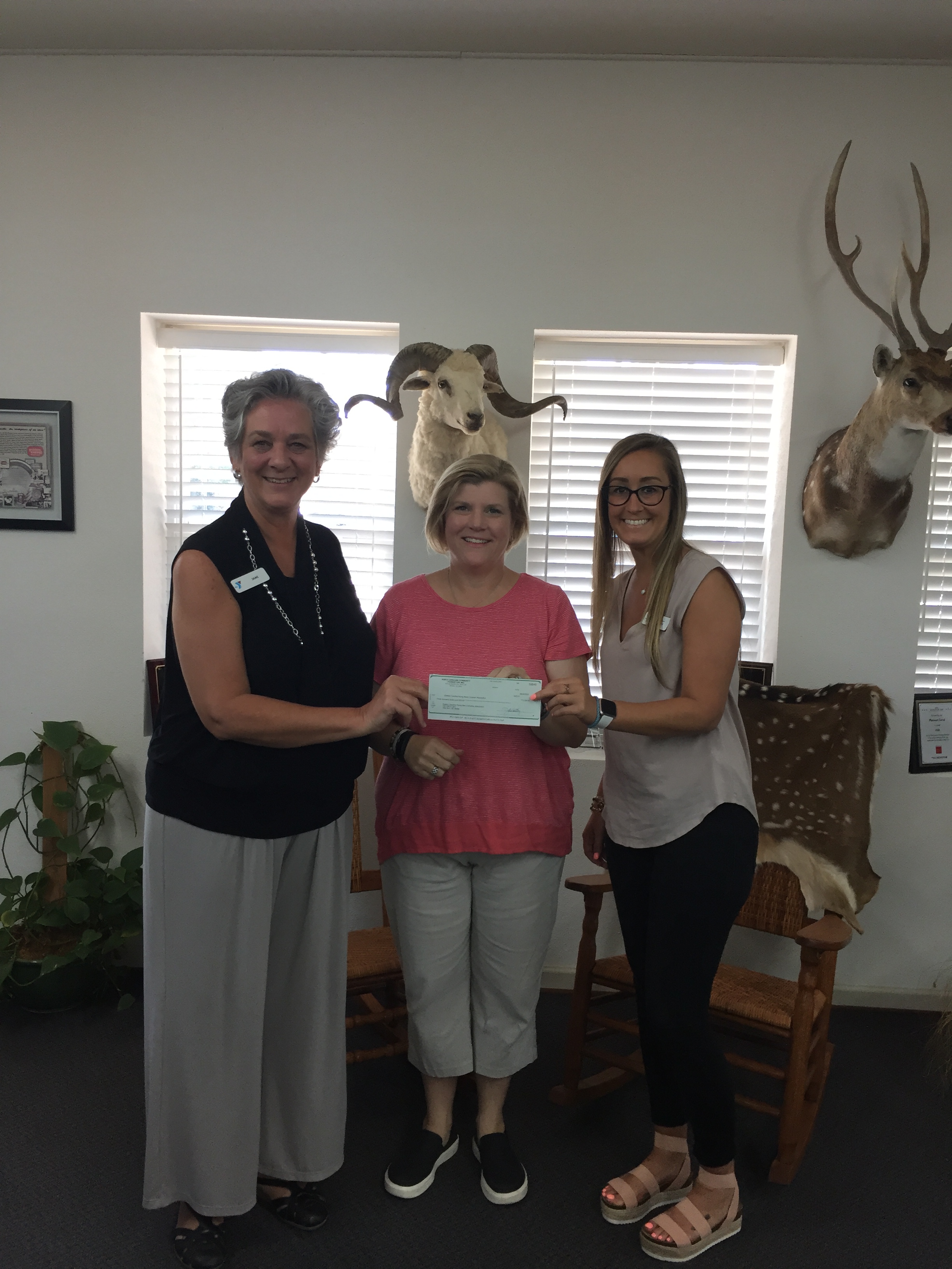 Julee Efird Sewell, Onslow Caring Communities Foundation chair, presenting a $3,000 grant check to New River YMCA Day Camp executive director and Youth & Family Services Director, Jane Schirmer and Marissa Cunningham, respectiely.