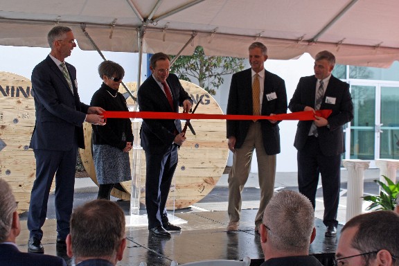 Clark Kinlin, Corning Executive Vice President, flanked by Newton Mayor Anne P. Stedman and Catawba County Board of Commissioners Chair C. Randall Isenhower, cuts the ribbon at Corning's Newton Facility. 