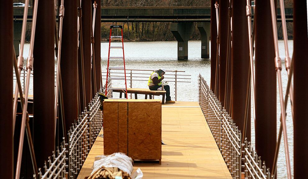 A construction worker enjoys his lunch break while sitting on a bench on the new Riverwalk on Lake Hickory earlier this month. The city expects the Riverwalk will be complete this summer.  ROBERT C. REED, RECORD