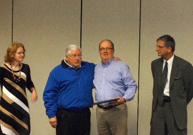 Ellie Bradshaw (EDC Chair), Rudy Wright (Hickory Mayor) and Randy Isenhower (Catawba County Board of Commissioners Chair) present recognition plaque to Frank "Burk" Wyattt, II (CommScope Vice President and General Counsel).  (Image: Catawba EDC)